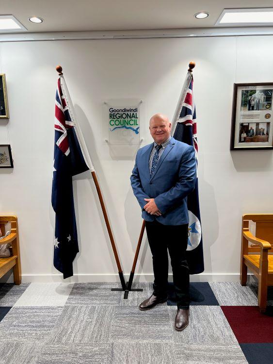 councillor mackenzie standing in front of the flags in the boardroom of Goondiwindi Regional Council Chambers